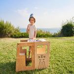 Kind gebruikt houten leertoren van Fits4Kids buiten in de tuin